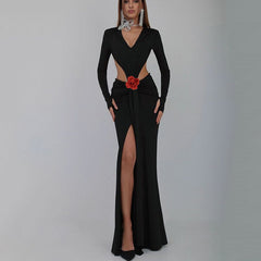 Black evening gown with a red flower detail on a gray background