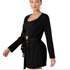 Woman wearing a black dress with long sleeves on a white background